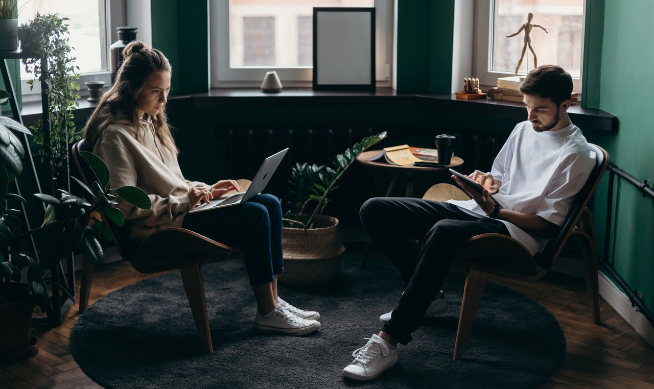 Dos jóvenes trabajando con sus portátiles